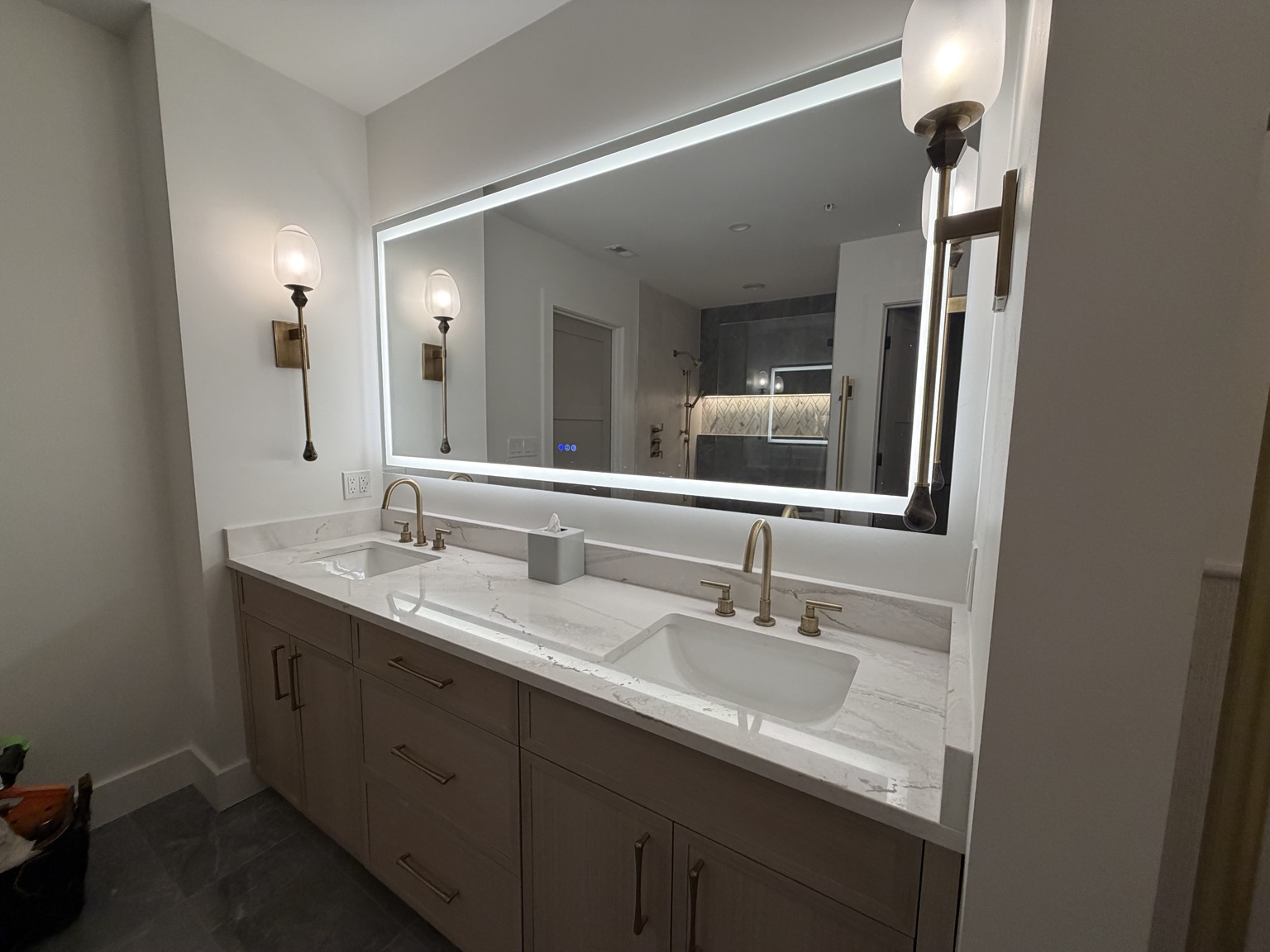 Completed double lavatory installation with two sinks and illuminated mirror