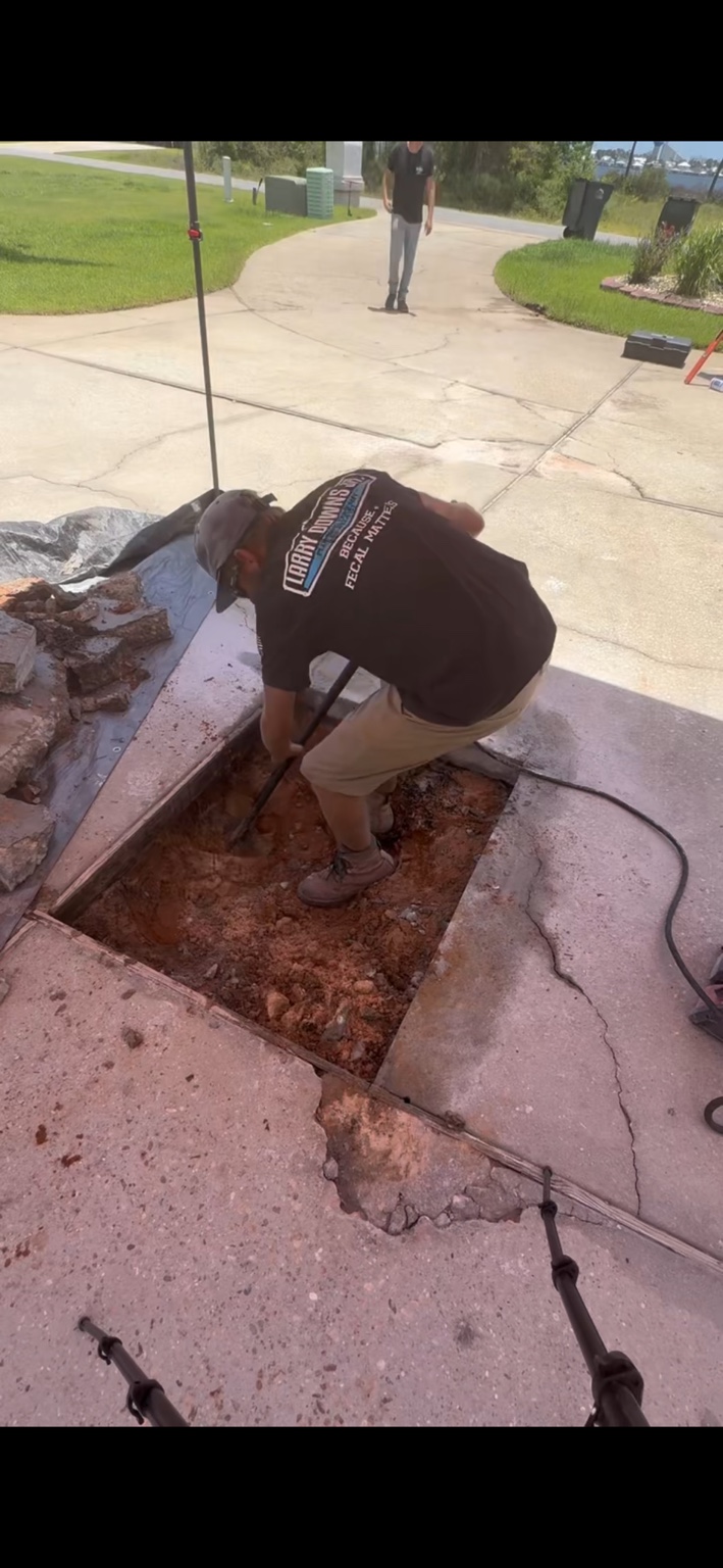 Technician excavating the precisely located leak beneath a driveway